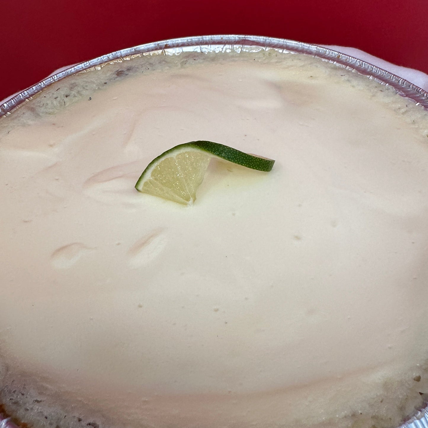A key lime pie, garnished with a lime wedge.