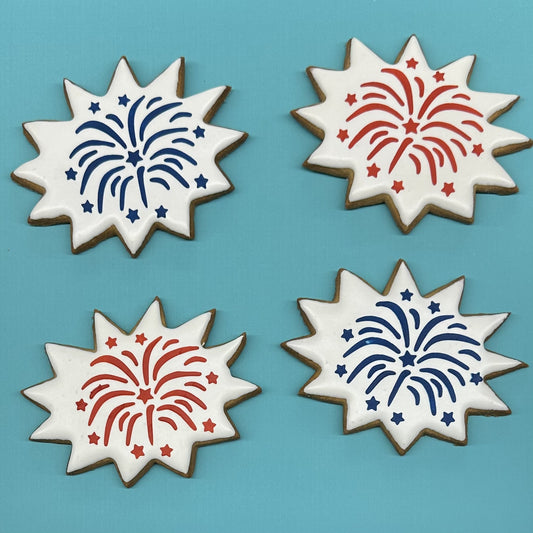 Four cookies with star-shaped designs of blue and red fireworks on a blue background